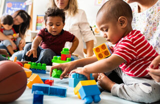 photo of chldren playing with blocks on floor